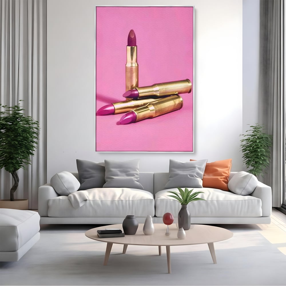 Tablou canvas cu tablou canvas cu rujuri in forme de cartuse pe fond roz, in rama de aluminiu argintiu, pe perete intr-un living